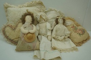group of accent pillows and 3 stuffed dolls