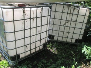 Pair of metal caged poly bulk tanks...