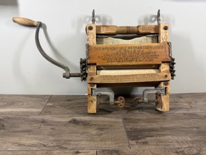 Antique hand-cranked clothes wringer (also known as a mangle), which was used in the late 19th and early 20th centuries to squeeze water out of wet laundry before hanging it up to dry.