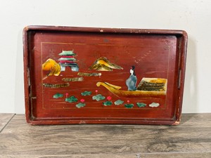 Vintage East Asian cinnabar-red lacquer serving tray, featuring a hand-painted and slightly raised relief landscape.