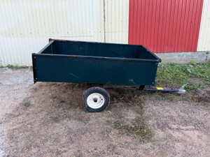 Ranch King tow-behind lawn dump cart (17 cu. ft. metal dump cart model) with a steel pull tongue and surface rust on the inside of the bed
