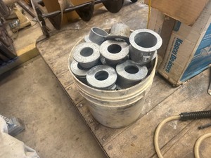 Bucket of 61 Galvanized 1-12 Vertical Pipe Feet, for Vertical Pipe Support on Black Top. Eliminates pipe marking into black top surface