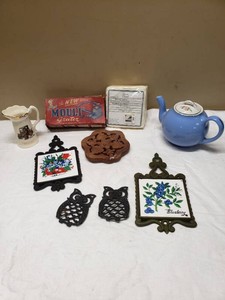 Kitchen and Home Decor Items Including Mouli Grater, Blue Teapot, Ceramic Pitcher, Owl Trivets, and Tile Trivets