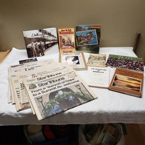 Books and Newspapers Collection with Minnesota Themes, Including Star Tribune Editions and Local Histories including local history books like Looking Back Kandiyohi County, Tales of the Road, and How to Talk Minnesotan.