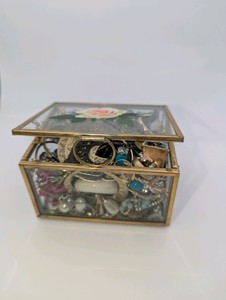Vintage floral-etched glass jewelry box filled with earrings