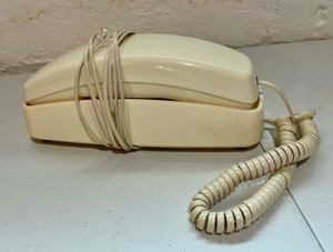 Vintage trimline corded telephone, retro beige wall mount landline phone