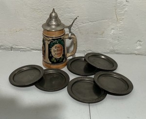 Vintage lidded German ceramic beer stein & lot of 6 pewter coasters