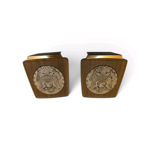 Vintage mid-century United States Great Seal bookends featuring a raised relief eagle medallion set in a wood-grain bakelite or resin body with gold-tone metal trim.