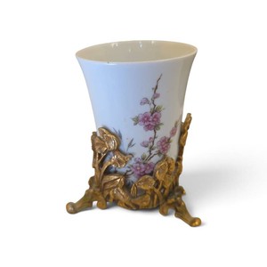 vintage porcelain cup features a delicate pink floral motif nestled in an ornate, footed gold-tone ormolu metal holder with a butterfly and leaf motif
