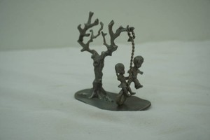 Vintage pewter sculpture of children playing on a tire swing. F. Robert Drury for International Pewter