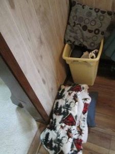 Laundry basket full of bed linens, accent pillows and blankets