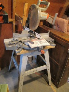 Ridgid 12in compound Miter Saw with metal framed stand, user manual and accessories shown