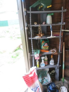 Wood corner shelf with lawn care supplies, misc ice melt, feed corn and auto bufferdetailer