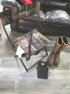 Camouflage fold up hunting chair with under-seat mesh storage, shotgun shell caddy and mens size 10 rubber boots