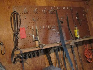 Vintage cast iron buggy adapter hooks, antique handsaw and misc horse tack