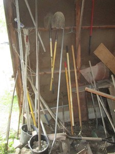 Collection of assorted shovels, pitch forks, rakes, hi-jack and musc long handle yard tools