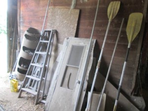 All content against wall as shown including boat oars, wood ladder, camper door, windows and more