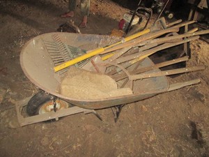 Metal bucket wheelbarrow with landscaping tool assortment