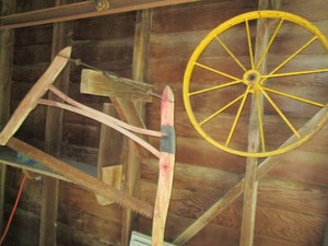 Antique wood framed cradle saw and metal chariot tire