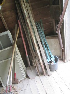 Collection of t-posts and long handle garden tools