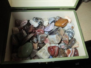 Small wood jewelry box containing a wide variety of agate rocks