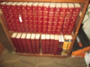 Wood bookshelf full of vintage encyclopedias and Year books. Shelf approx 28x16x31in