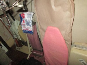 Vintage upright vacuum cleaners with replacement bags, automotive floor mats, medical crutch aids and assorted size ironing boards