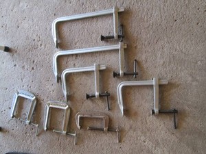 Collection of assorted c-clamps and sliding arm bar clamps