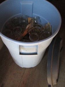 26-gallon Rubbermaid roughneck trash can with lid containing assorted cutlass canning jars
