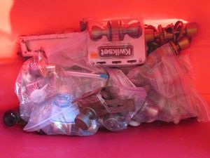 Covered Tote of assorted antique metal door knobs, hardware and mechanisms