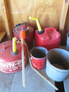 Vintage metal pails and assorted gas cans with hand siphon
