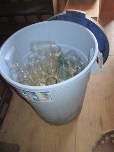 26-gallon Rubbermaid roughneck trash can with lid containing assorted glass canning jars