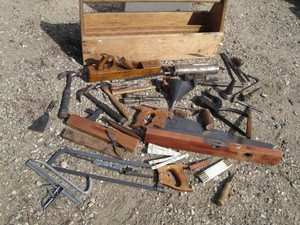Wood top handle toolbox with a wide variety of vintage hand tools including pliers, chisels, pipe wrenches, hammers, saws, measuring sticks, levels, planer, oil cans and more