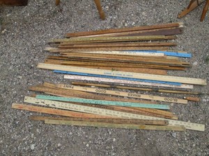 Collection of assorted vintage yardsticks and misc wood handled tools