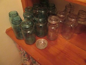 Variety of clear and colored glass lidded and non-lidded canning jars