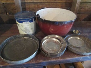 Enamelware pot, lidded tin and assorted vintage metal advertisement lids