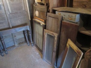 Variety of vintage wood furniture parts including table legs, windows, shelves and more