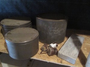 Vintage lidded tins, insulators and whetstone