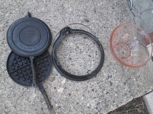 Cast iron Wagner Ware waffle iron and pink depression Era glass mixing bowl