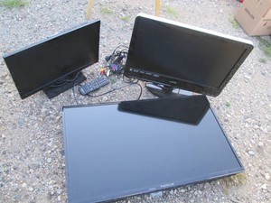 Assorted size flat screen TVs with remotes and misc cables