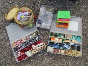 Compartmentalized organizers and covered basket with a large variety of sewing buttons and notions plus hot glue gun