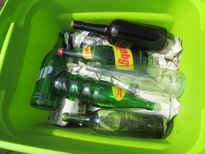 Lidded tote containing a variety of glass soda bottles 1