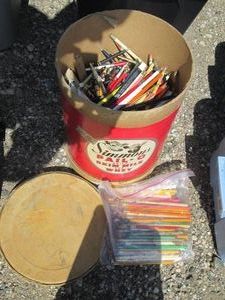 Vintage dairy container full of rulers, pencils and other writing implements