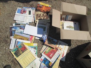 Box of vintage wall calendars in assorted themes from various locations
