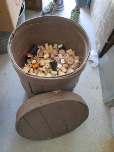 Vintage barrel of empty thread spools, mostly wood