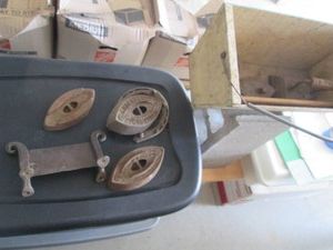 Vintage wood top handle tool box with a various sad irons and cast iron horse shoe