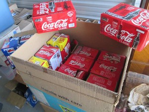 Box of vintage Coca-Cola and Pepsi cans with cardboard packaging