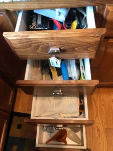 Assorted kitchen utensils, embroidered dish towels, pot holders, wood rolling pin, cake decorating items all in 4 drawers