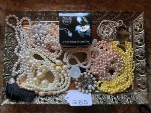 Mirrored tray with pearl like necklaces and Wish Pearl