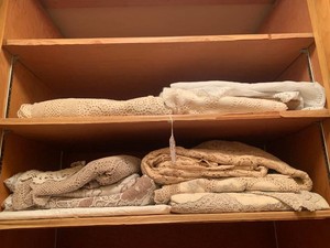 Crocheted and other table cloths all on top 2 shelves